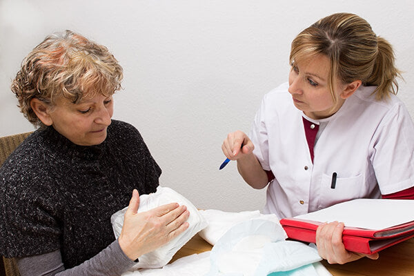 Un'infermiera parla delle mutandine per incontinenza con una paziente