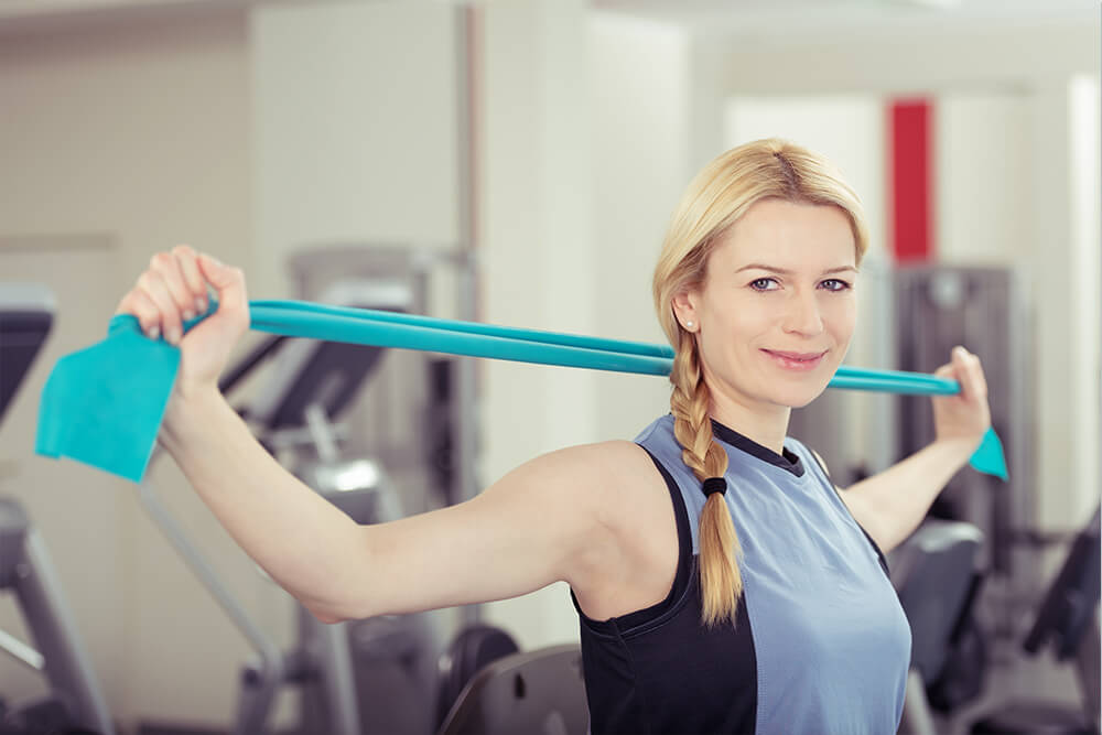 Una donna usa bande elastiche Theraband per allenarsi
          Didascalia: le fasce Thera sono versatili.