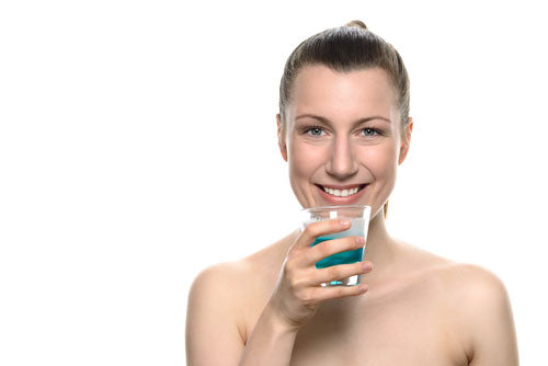 Donna con un bicchiere di collutorio